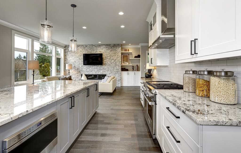 Northshore Renovations & Contracting, LLC: The Leading Contractor For Kitchen Renovations In St. Tammany Parish image of large, modern, luxury Kitchen with open floor plan, white cabinest with granite countertops, modern lighting over kitchen island