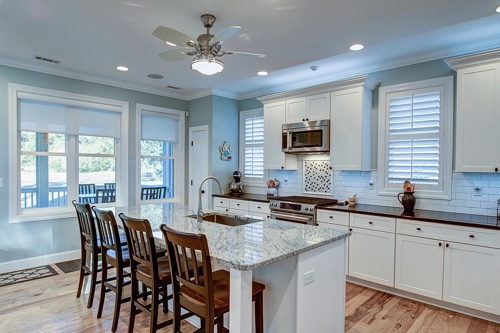 Best Custom Windows For Improved Natural Light in St. Tammany Parish with Northshore Renovations & Contracting; image of bright white open kitchen with 6 windows in total