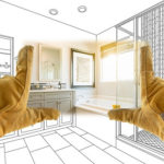 How Long Does It Typically Take to Renovate a Bathroom? | Northshore Renovations and Contracting, Covington, Mandeville, and Madisonville, LA. Image of a male contractor’s hands framing a completed bathroom over a drawing.