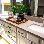 Bathroom Vanities: How They Fit in Bathroom Renovations | Northshore Renovations and Contracting in Mandeville, LA. Image of a master Bathroom with vanity, dual sink, and a tray of decorator items.