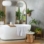 Modern white tub and beautiful green houseplants in bathroom renovation.