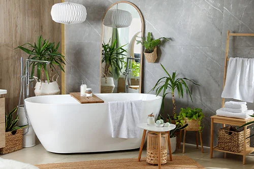 Modern white tub and beautiful green houseplants in bathroom renovation.