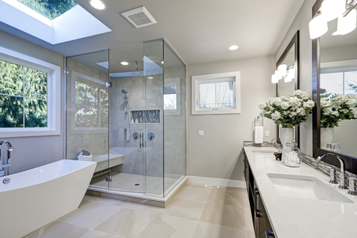 transform your bathroom with custom renovations in St. Tammany LA area with Northshore Renovations and Contracting. Image of newly renovated spacious bathroom with tub, separate shower, double sinks and gray-toned cabinets, and floors.