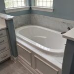 Custom bathroom project design and contractors near me in Madisonville, LA St. Tammany Parish with Northshore Renovations and Contractors. Image of custom built white marble garden tub in bathroom renovation.